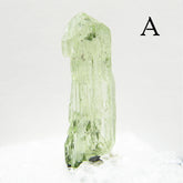 Tall Light green Diopside crystal against light background