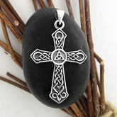 Silver cross pendant with Celtic design on a black stone with a natural background