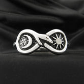 Silver Figure of Eight Snake Ring with Crescent Moon and Sun on black background.