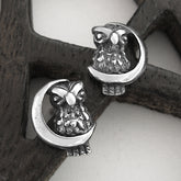 Silver owl and crescent moon earrings on a wood pentagram.