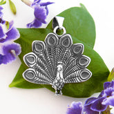 Nature-inspired sterling silver peacock pendant with detailed feathers fanned out open oxidized finish.