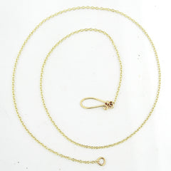 A delicate gold chain necklace with a handmade clasp in a spiral on a white background