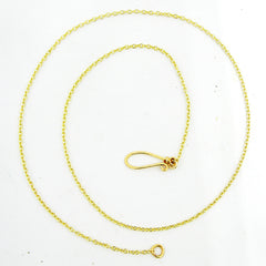 A gold-plated chain necklace with a handmade loop clasp arranged in a spiral on a white background.