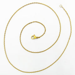 A gold flat cable chain necklace with a lobster clasp and extension loop, arranged in a spiral on a plain white background.
