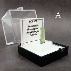 Sample of tall Light green Diopside crystal in plastic case labeled with dark background
