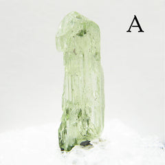 Tall Light green Diopside crystal against light background