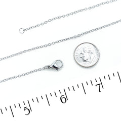 A stainless steel chain necklace with a lobster clasp and extender, shown on a white background with a coin and ruler for scale.