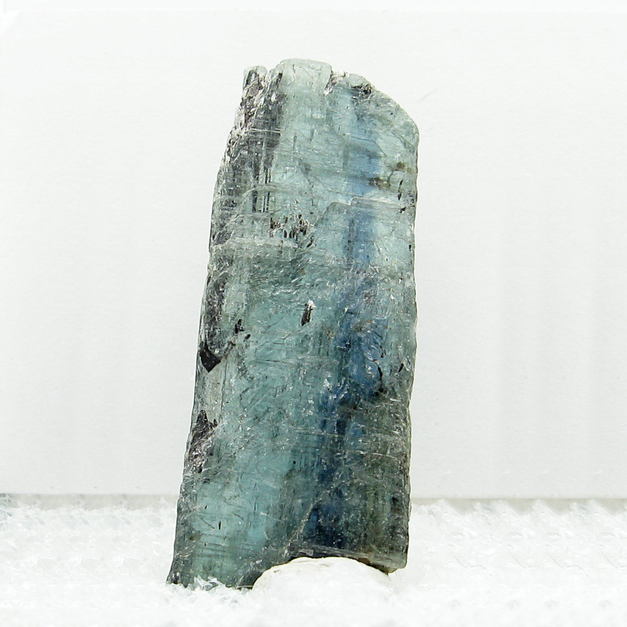 Front view of rectangular blue kyanite specimen on white background.
