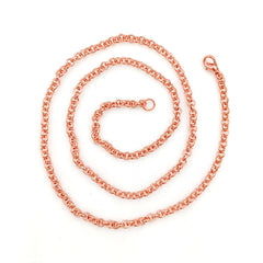 A copper rolo chain necklace with a classic curb link pattern, coiled in a spiral on a clean white background. It features a lobster clasp at one end and an extender link section in the center.