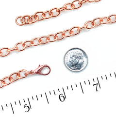 A close-up of a heavy copper cable with a lobster clasp, shown alongside a dime for scale and a measurement ruler on a white background.