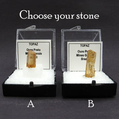 2 specimens of Brazilian 'honey' topaz gemstones labeled in plastic cases on dark background.