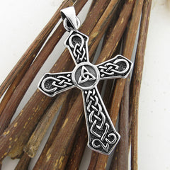 Silver cross pendant with Celtic design on a wooden background