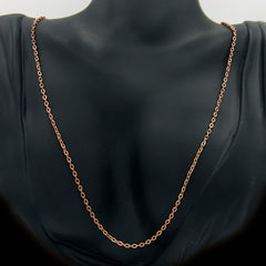 A copper cable chain hanging on a black mannequin against a white background.