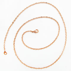 A copper cable chain with lobster clasp arranged in a spiral pattern on white background.