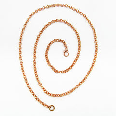 A copper cable chain with lobster clasp arranged in a spiral pattern on white background.