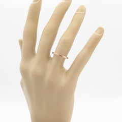 Slender flat faced copper band ring worn on the hand of a mannequin with a white background.
