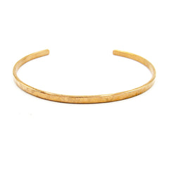 Front view of a gently hammered narrow copper open-cuff bracelet on a white background