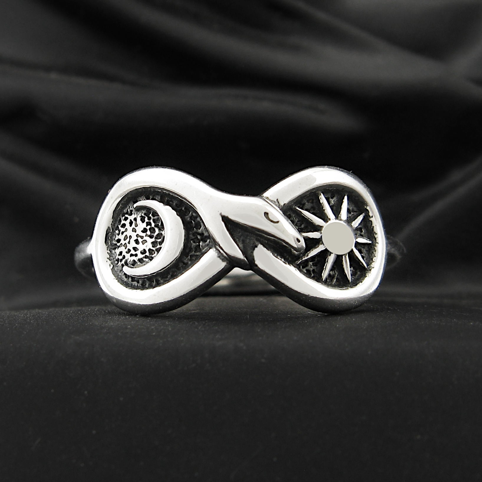 Silver Figure of Eight Snake Ring with Crescent Moon and Sun on black background.