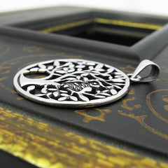 Side view of round sterling silver cut-out pendant with owl in tree design