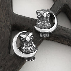 Silver owl and crescent moon earrings on a wood pentagram.
