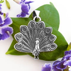 Nature-inspired sterling silver peacock pendant with detailed feathers fanned out open oxidized finish.