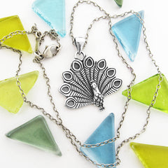 Three-dimensional sterling silver peacock totem pendant with detailed feathers fanned out open oxidized finish with chain.