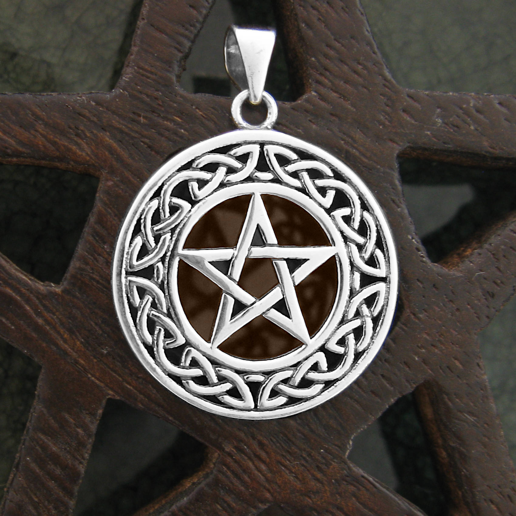 925 sterling silver pentagram pendant with Celtic knot border on wooden background