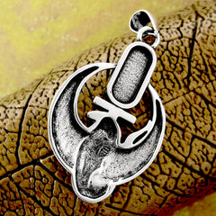 Back side of silver pendant with bird-like shape on gold and yellow background