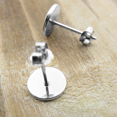 Rear view of pair of 925 sterling silver spiral stud earrings silver on wood background