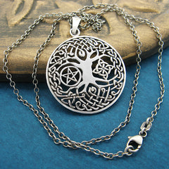 Front view of cut-out Tree of Life pendant with chain on gold disk with green background.