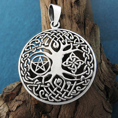 Front view of cut-out Tree of Life pendant on wood branch with green background.
