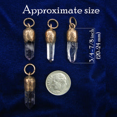 Four small veracruz amethyst point pendants with textured gold caps and loops are arranged on a dark blue fabric background, with text reading 'Approximate size' and a U.S.