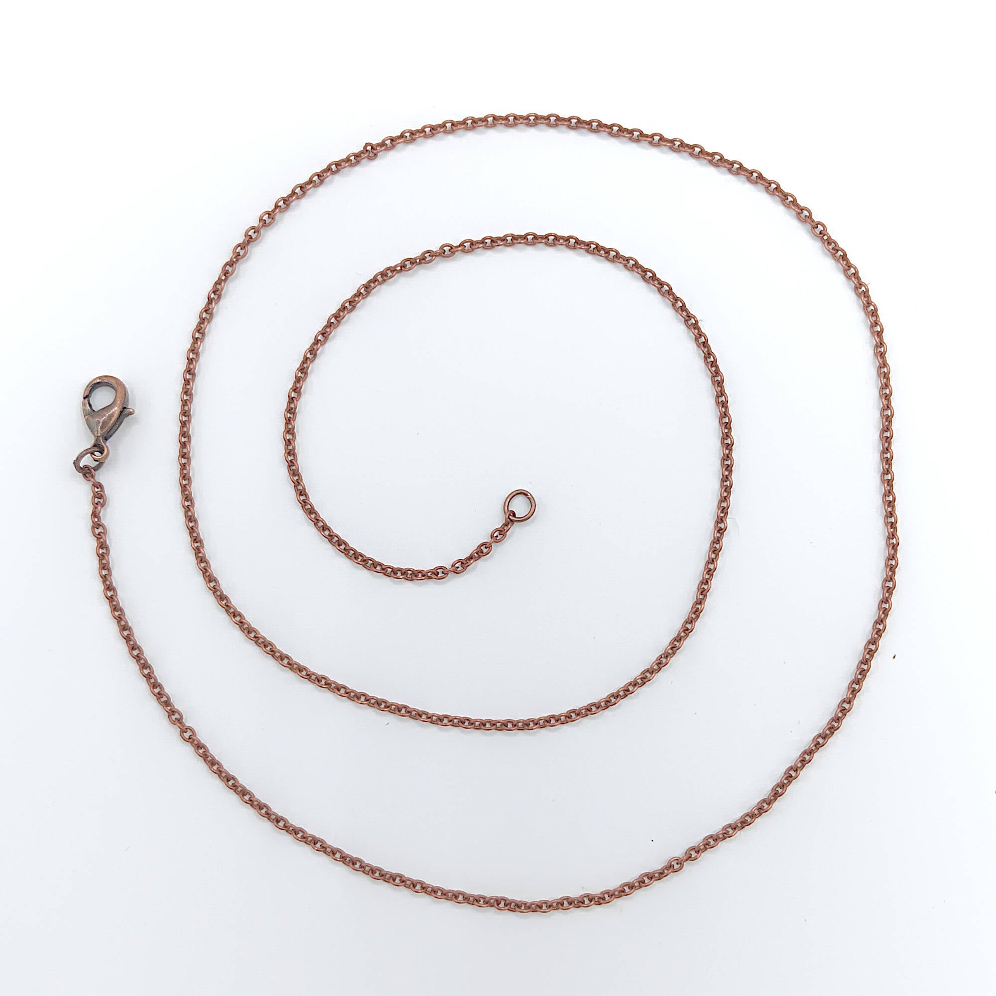 oxidized dainty copper necklace shown as a coil