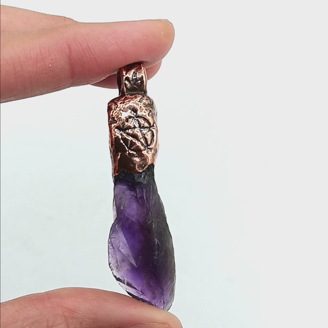 Raw amethyst crystal pendant with copper cap, pentagram stamp, and bindrunes for protection, safe travels, strength, and good luck.