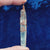long clear copper wire wrapped quartz crystal with spiral designs against a dark blue background