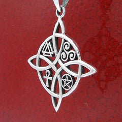 Angled side view of a silver witch's knot pendant with four symbols against a crackled red glazed finish