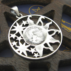 Back side of cut-out sterling silver pendant with sun moon and stars design on wood background