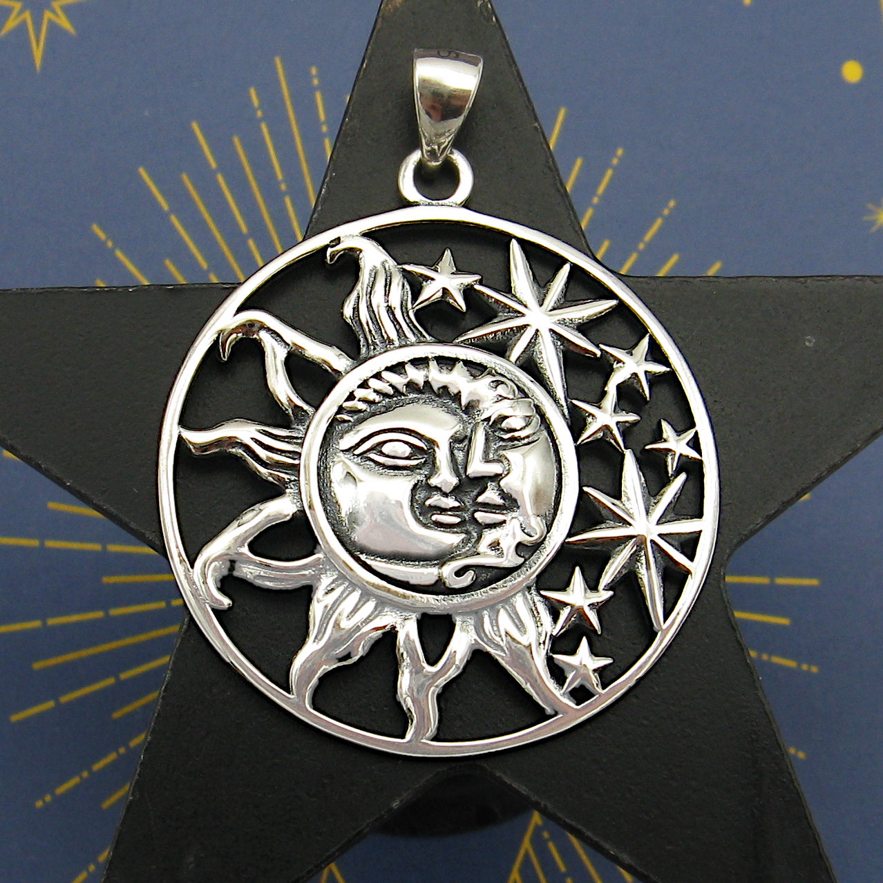 Cut-out sterling silver pendant with sun moon and stars design on dark background