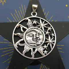 Cut-out sterling silver pendant with sun moon and stars design on dark background