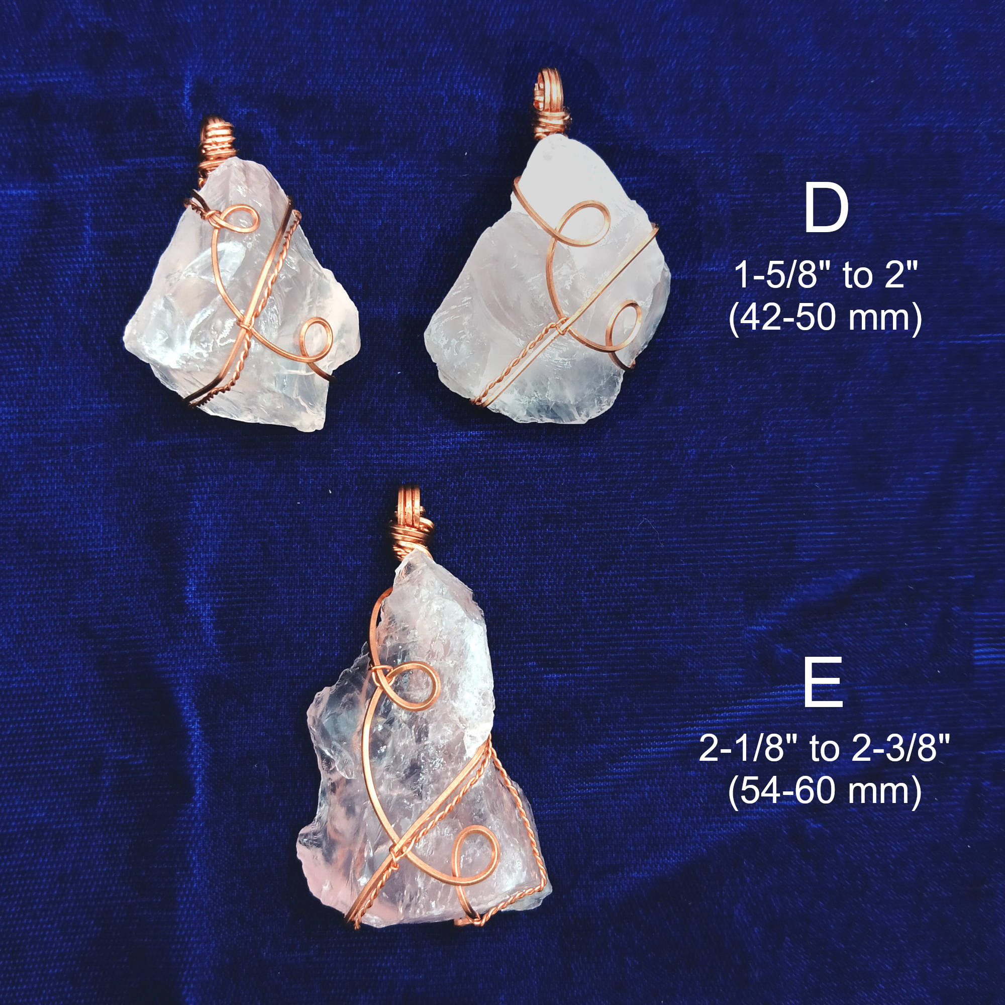 Three rose quartz pendants with copper wire wrapping on a blue fabric background, showing measurements.