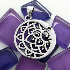 Round cut-out silver pendant with crescent moon and lotus design on purple glass mosaic tiles on white background