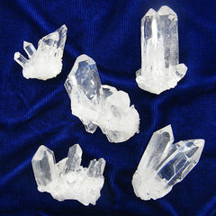 View of 5 different clear quartz crystal clusters on a dark background