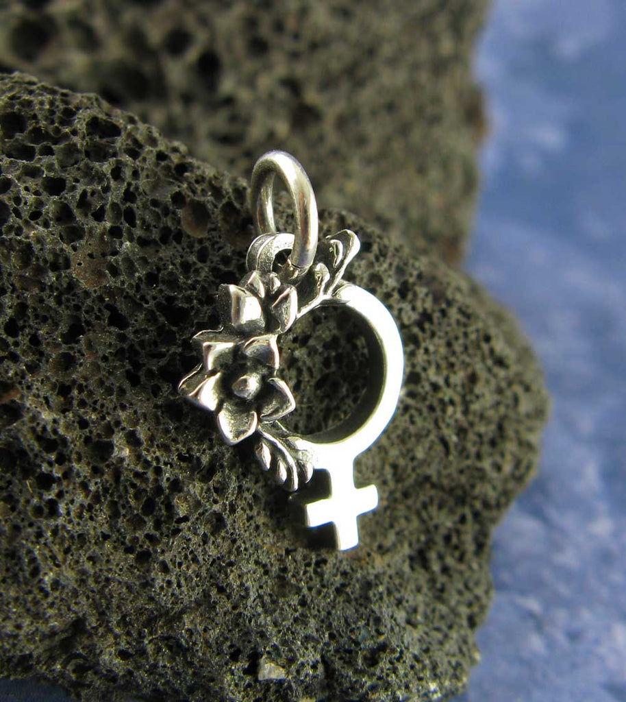 Tiny Feminist Symbol Pendant Charm Necklace Pro Choice Roe v Wade Women's Abortion Rights Jewelry Female Pride Woman Girl Power Feminism in front of lava rock