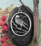 Raven Perched In Tree Oval Pendant
